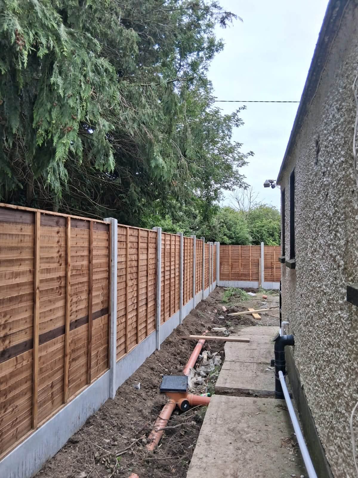 Long timber boundary fence with concrete posts